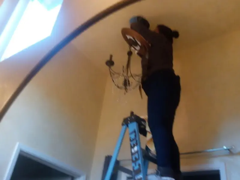 Electrician installing a chandelier in a Rocky River residence